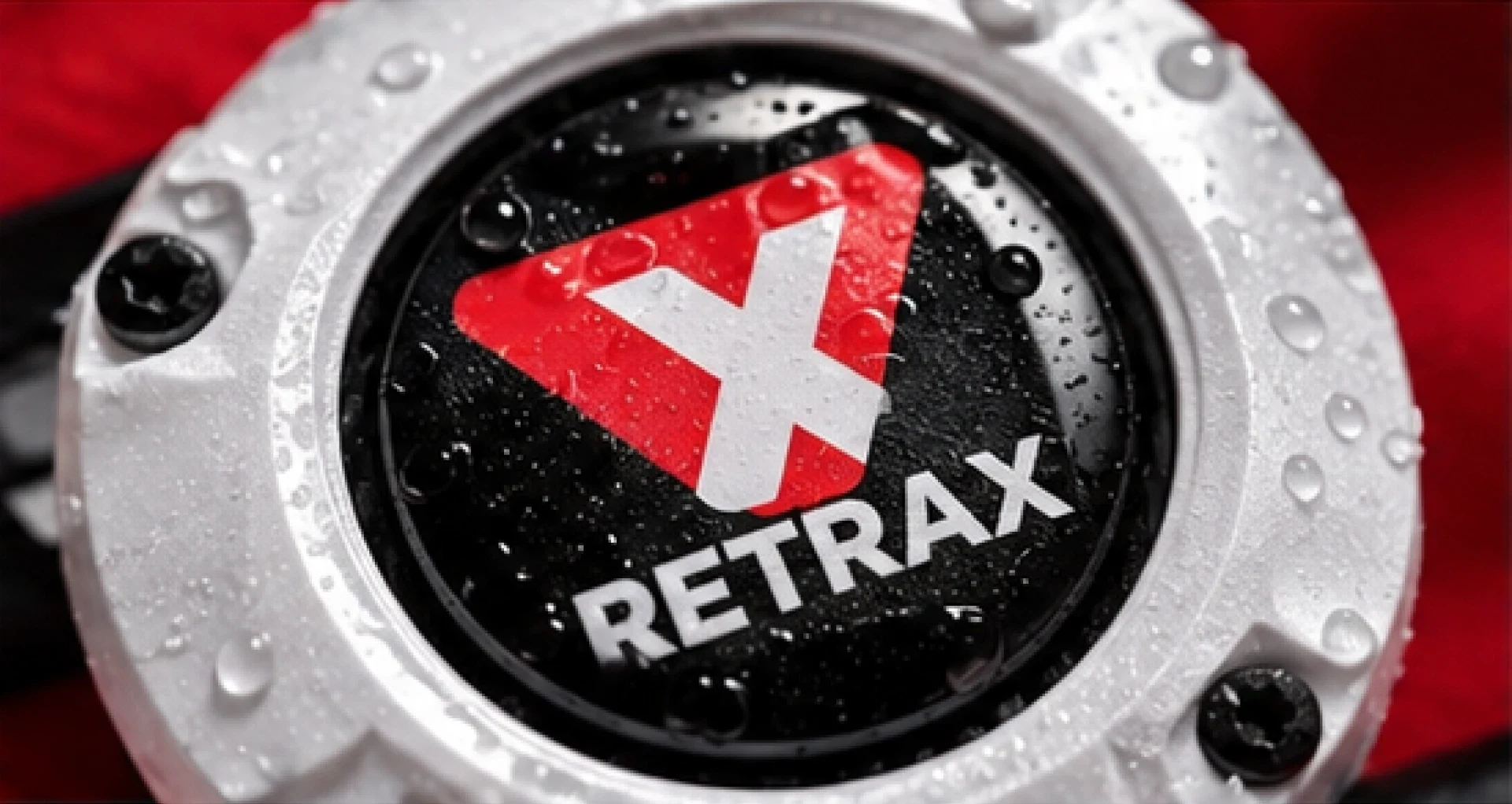 Detalle de RETRAX blanco con gotas de agua y logotipo